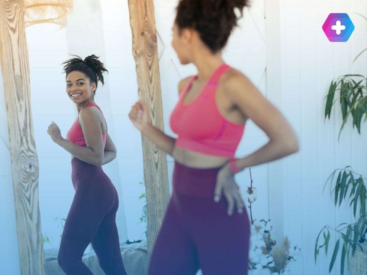 Athletic woman looking in the mirror after taking weight loss medications