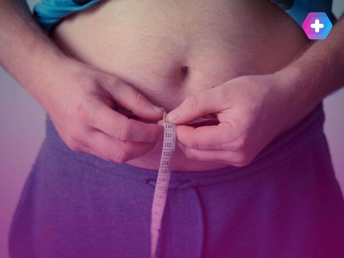 person measuring their waist with measuring tape