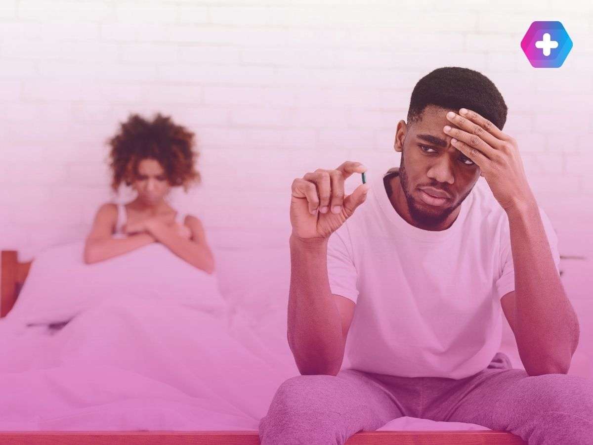 man sitting on edge of bed with blue tablet while woman sits behind him