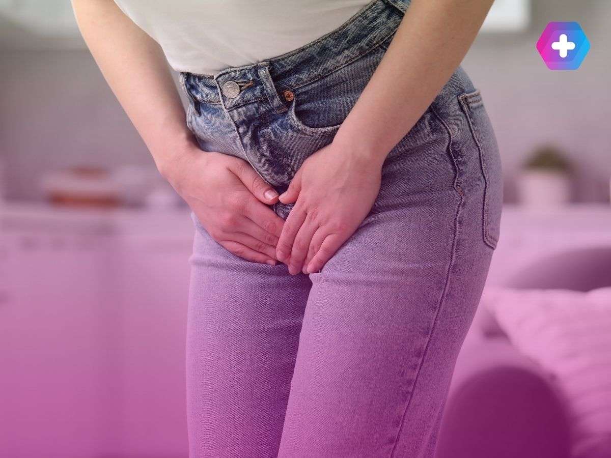 woman wearing jeans clutching lower stomach