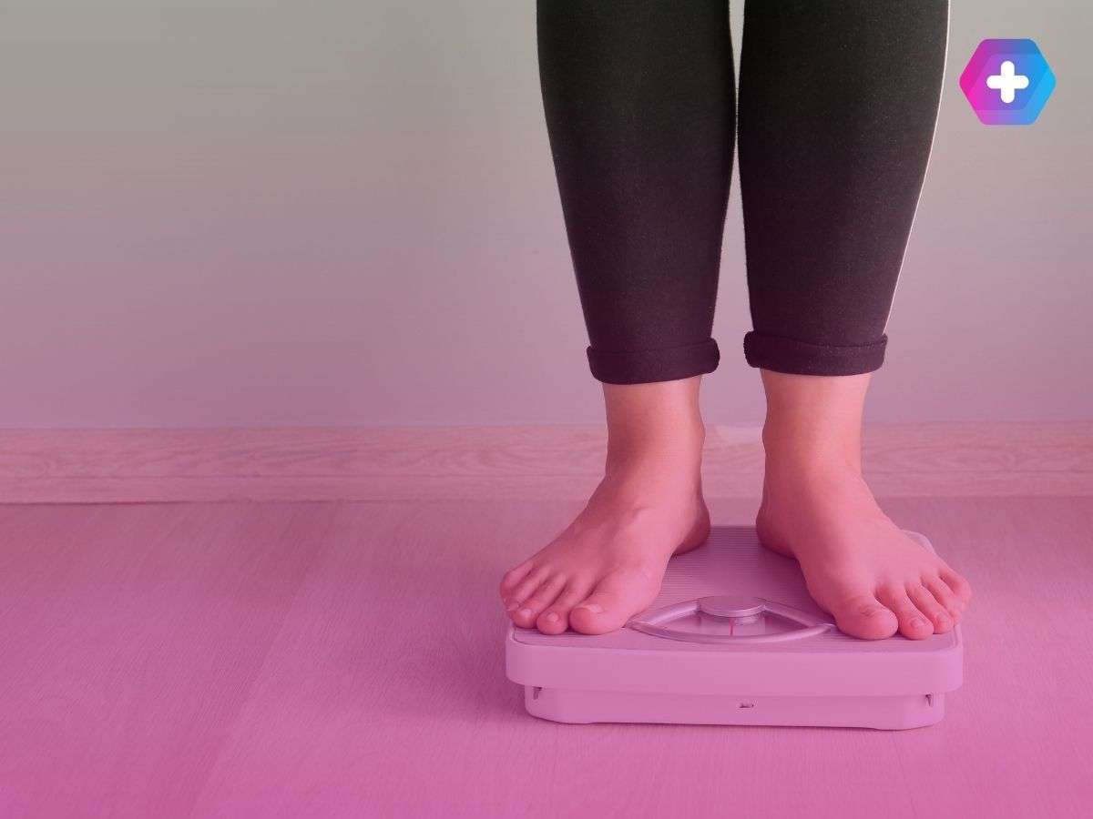person wearing black trousers standing on scales