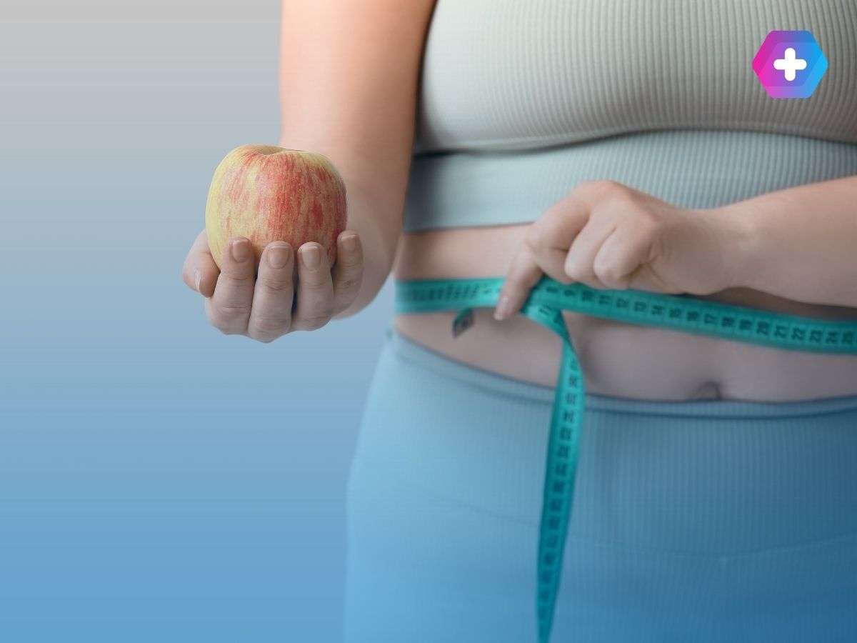 Woman measuring weight loss and eating an apple
