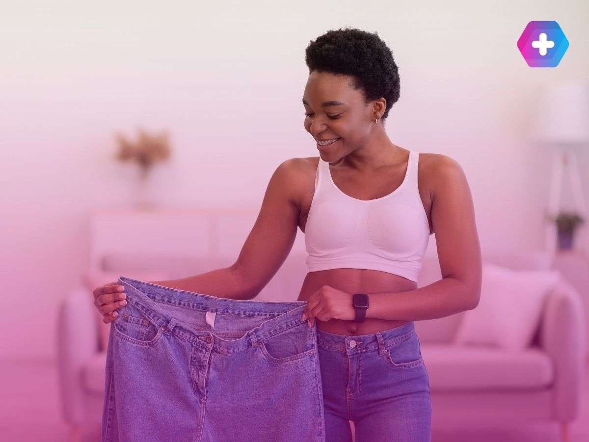 woman smiling and holding jeans too big for her