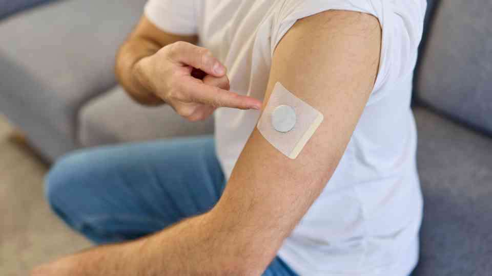 man pointing to testosterone replacement patch on arm