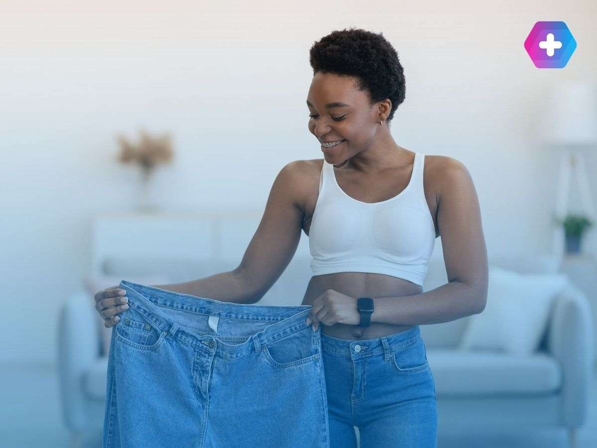 Woman holding old, big jeans after weight loss