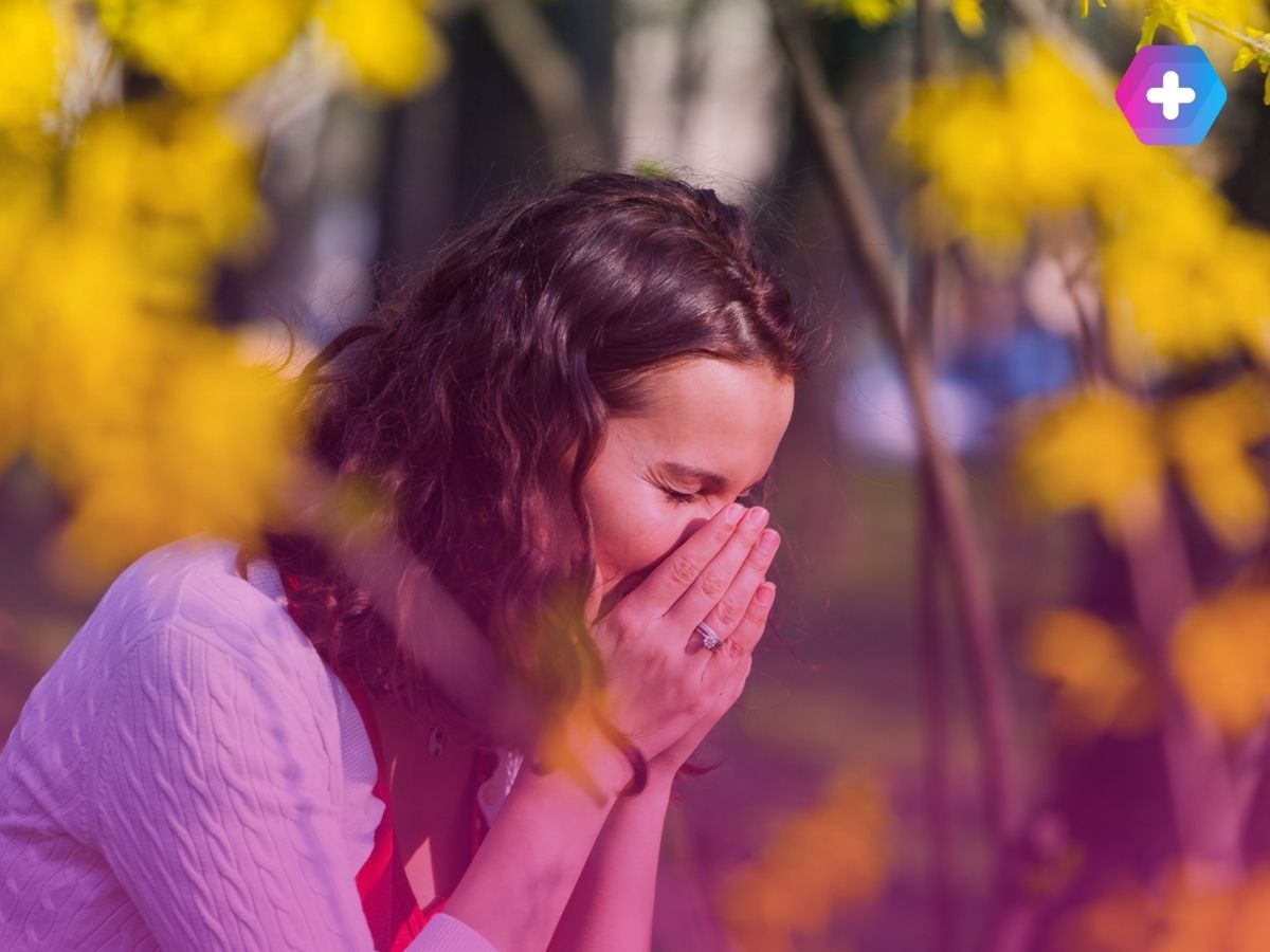 young woman sneezing near yellow flowers