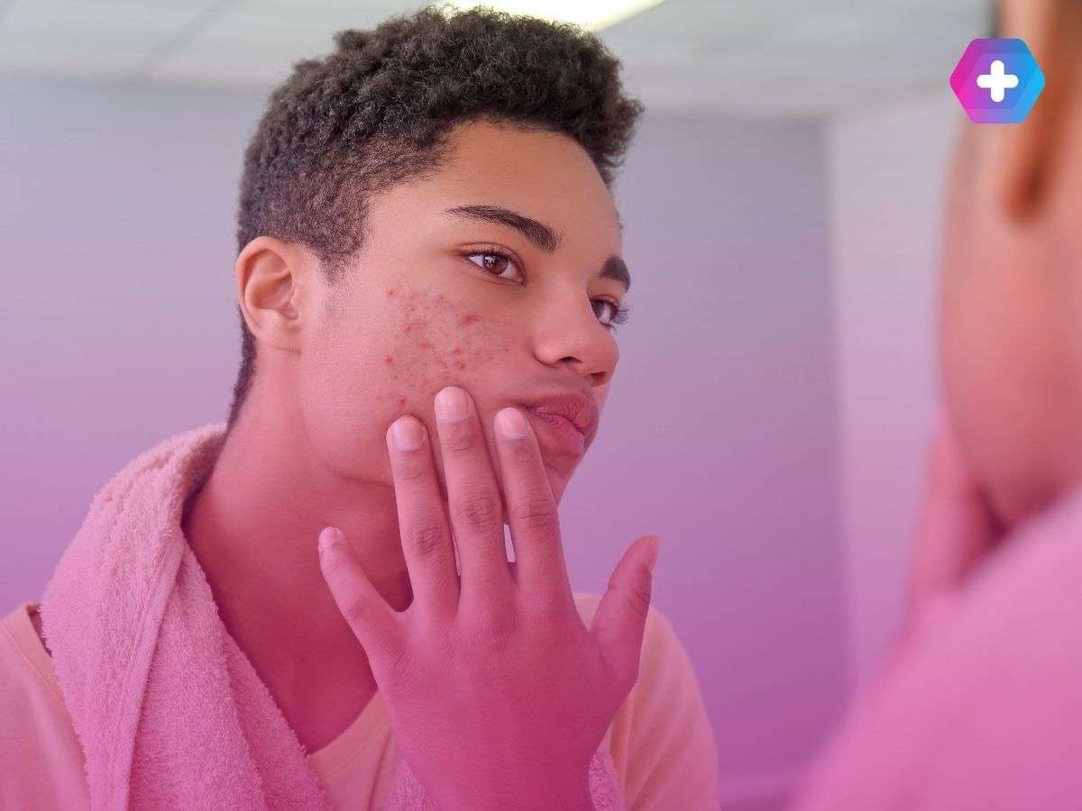 young man looking in mirror at spots on face