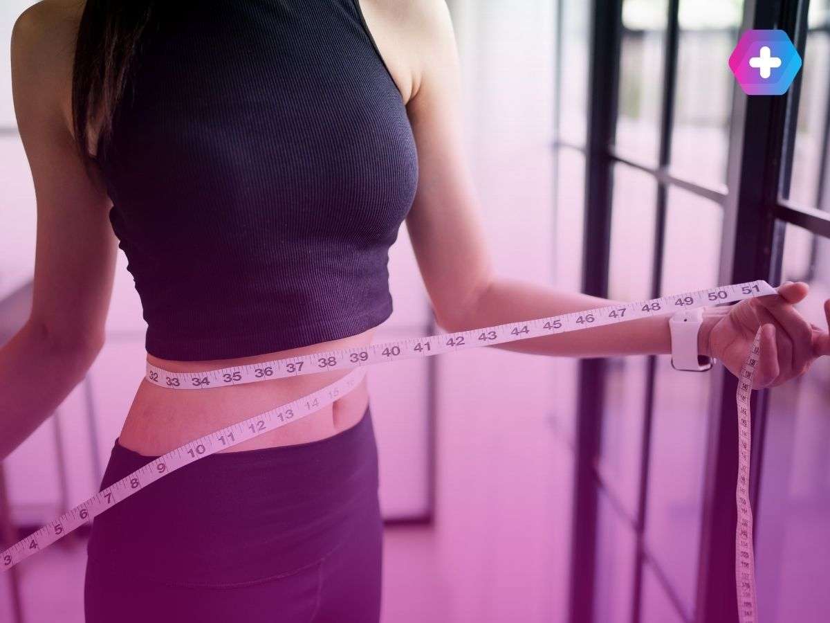 woman in black workout gear measuring waist
