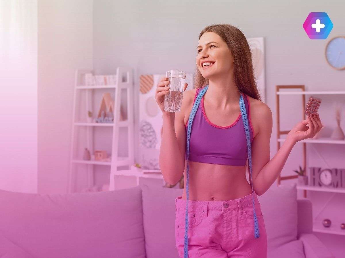 young woman in workout gear holding glass of water and weight loss pills