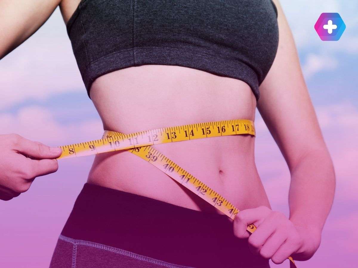 woman in workout gear measuring waist with yellow measuring tape
