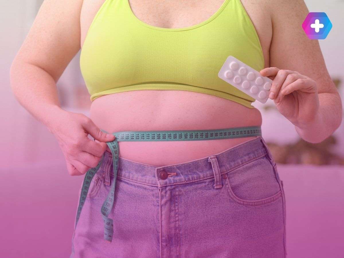 woman in yellow crop top measuring waist holding weight loss pills